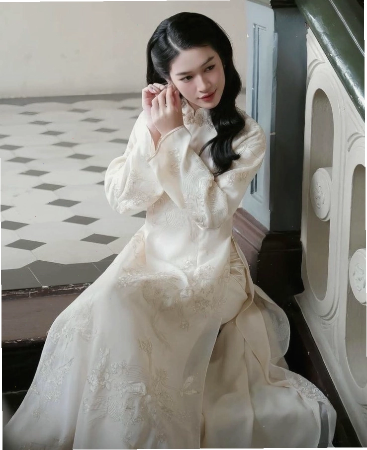Áo dài cách tân màu hồng phấn, cổ tròn, tay lỡ, chất liệu lụa mềm mại.