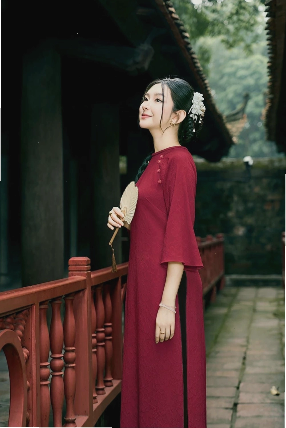 Áo dài cách tân tay dài, cổ V, màu xanh dương đậm, họa tiết phong cảnh, phối cùng quần trắng