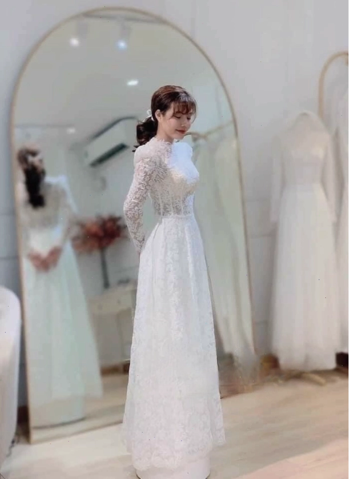Áo dài cưới màu hồng pastel với họa tiết hoa thêu và quần lụa trắng
