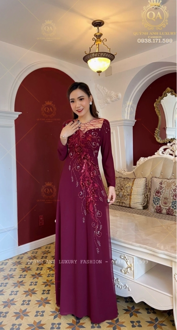 Áo dài dạ hội dáng cape màu đỏ mận sang trọng, cổ tròn, tay dài, đính kết ngọc trai tinh xảo