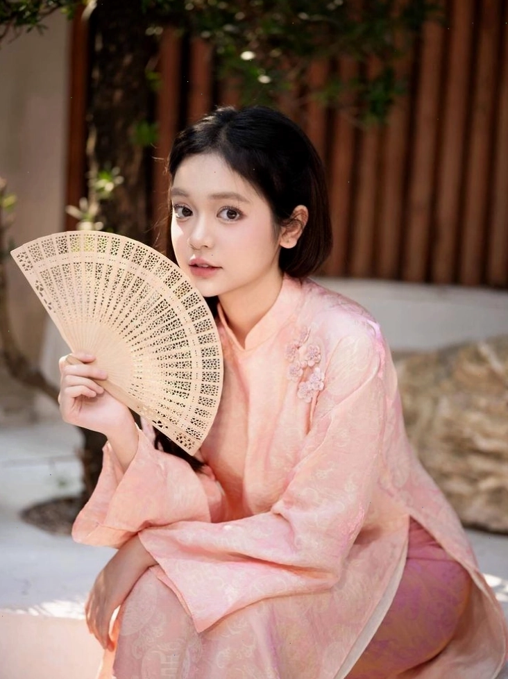 Áo dài đỏ đô họa tiết phượng hoàng, cổ tròn, tay lỡ, kết hợp quần đen và túi kẹp nách