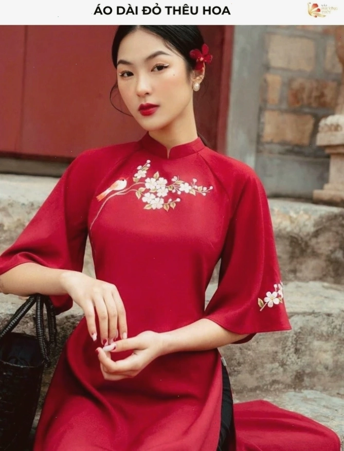 Áo dài đỏ rực rỡ cổ tròn thêu họa tiết hoa nhỏ li ti, tay áo dài ôm sát