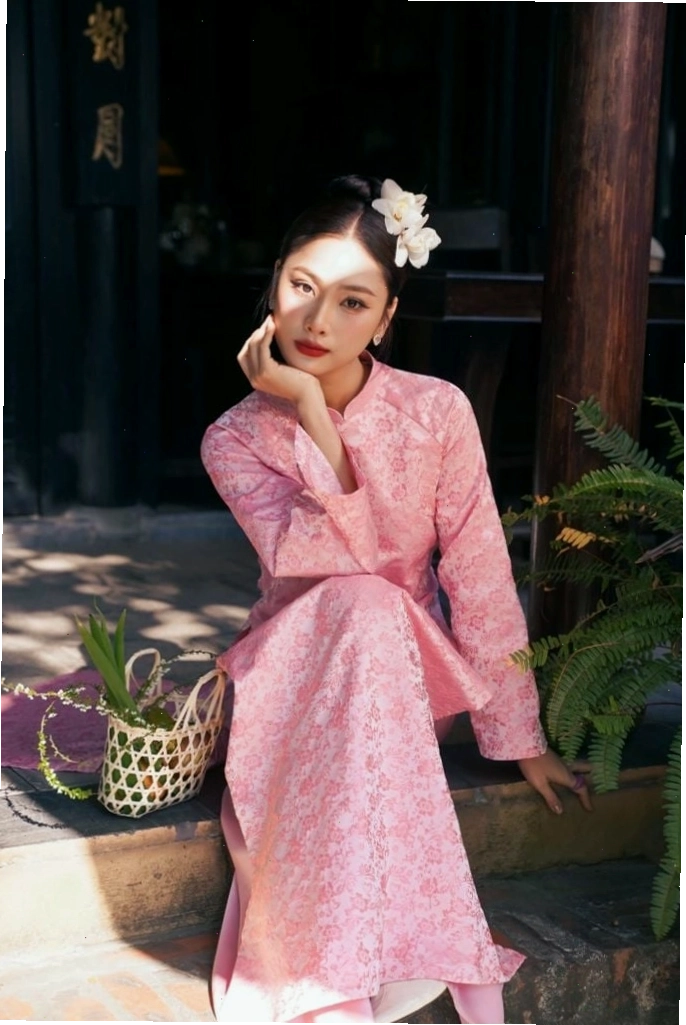 Áo dài gấm màu xanh ngọc bích, cổ cao, tay lỡ