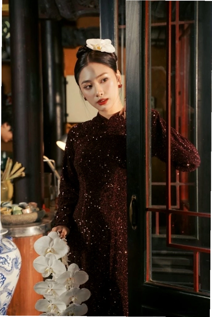 Áo dài kim sa lấp lánh, cổ thuyền, tay dài, tôn lên vẻ quyến rũ và sang trọng.