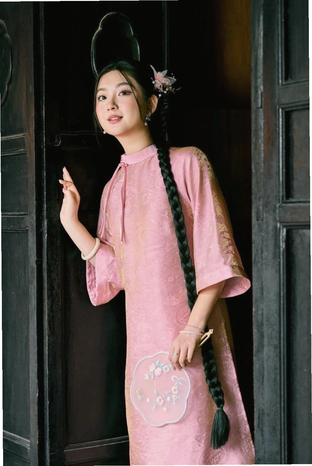 Áo dài lụa đen tuyền, cổ tròn, tay lỡ, họa tiết đính kết đá lấp lánh.