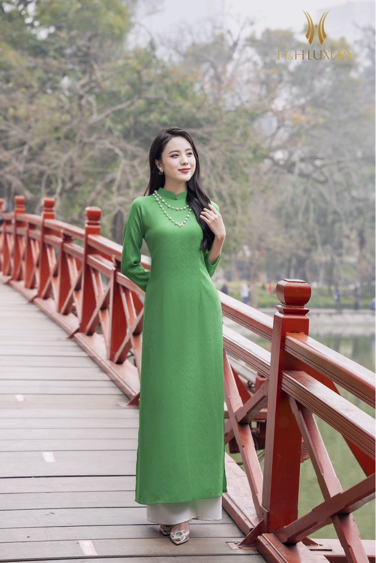 Áo dài lụa gấm hoa cúc xanh, tay phồng nhẹ, tà áo bay bổng.