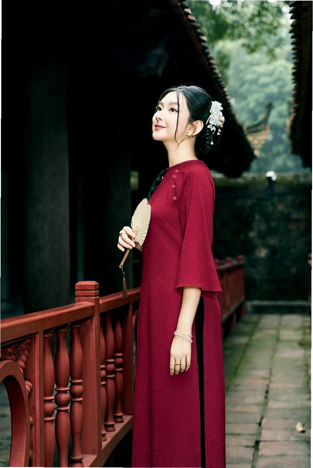 Áo dài lụa hai lớp màu xanh ngọc bích, cổ tròn, tay lỡ, họa tiết lá cây.