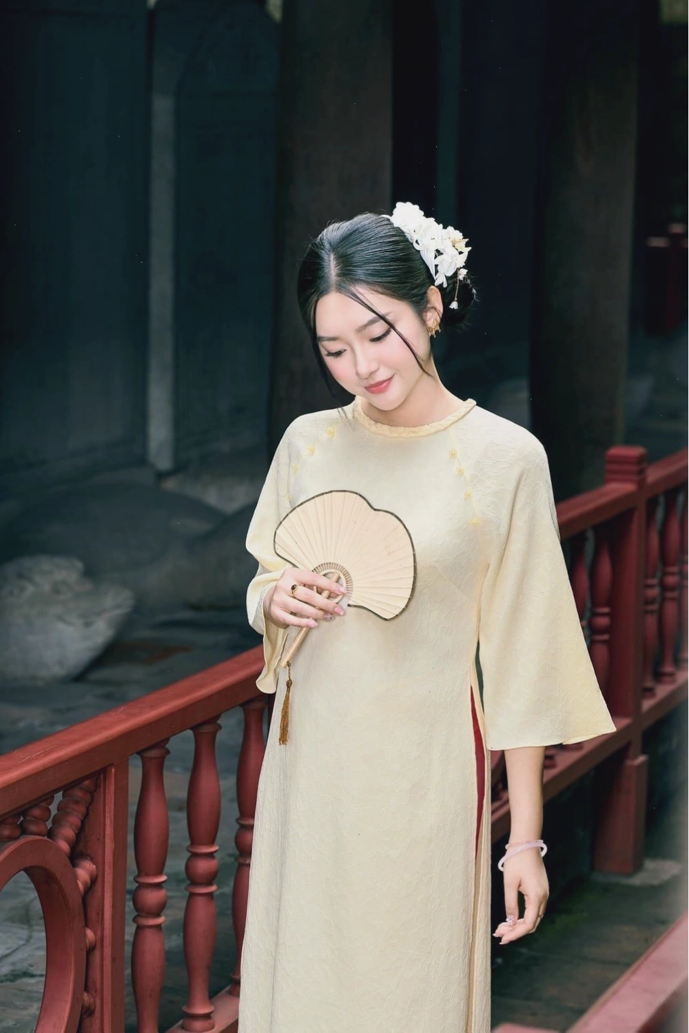 Áo dài lụa màu hồng sen, cổ tròn, tay lỡ, họa tiết hoa văn.