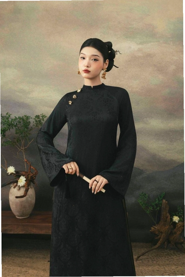 Áo dài lụa màu kem, cổ tròn, tay lỡ, họa tiết hoa văn tinh tế.