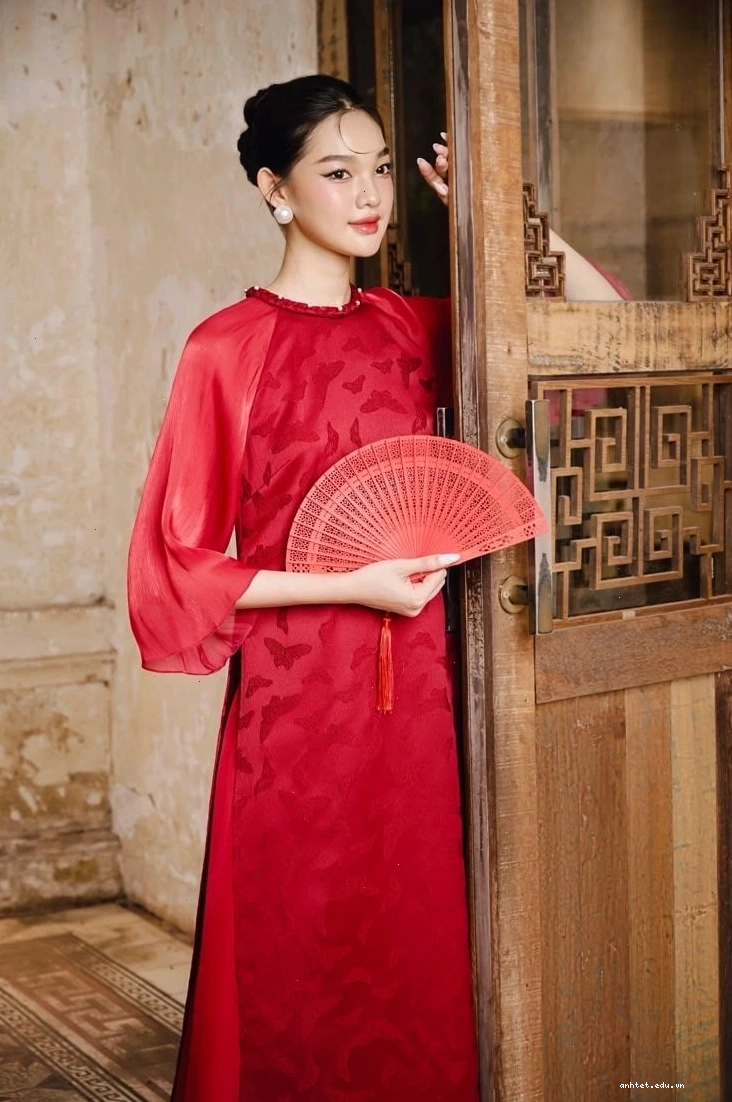 Áo dài lụa tơ tằm màu trắng với họa tiết cánh bướm và hoa, cổ tròn, tay lỡ.