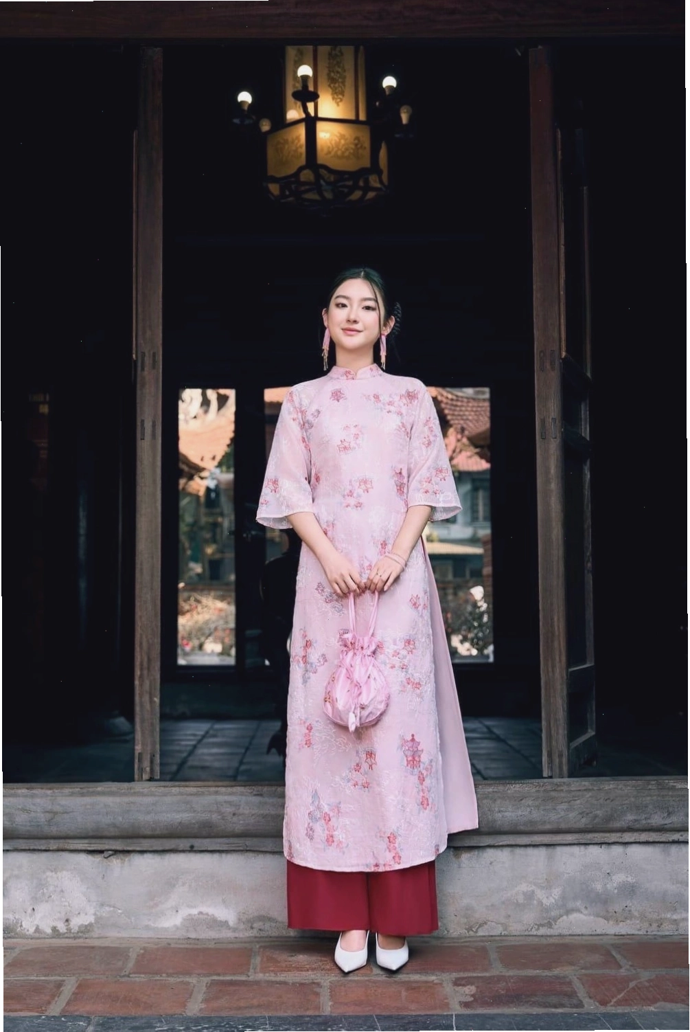 Áo dài lụa xanh coban, cổ tròn, tay lỡ, họa tiết hoa văn cách điệu.
