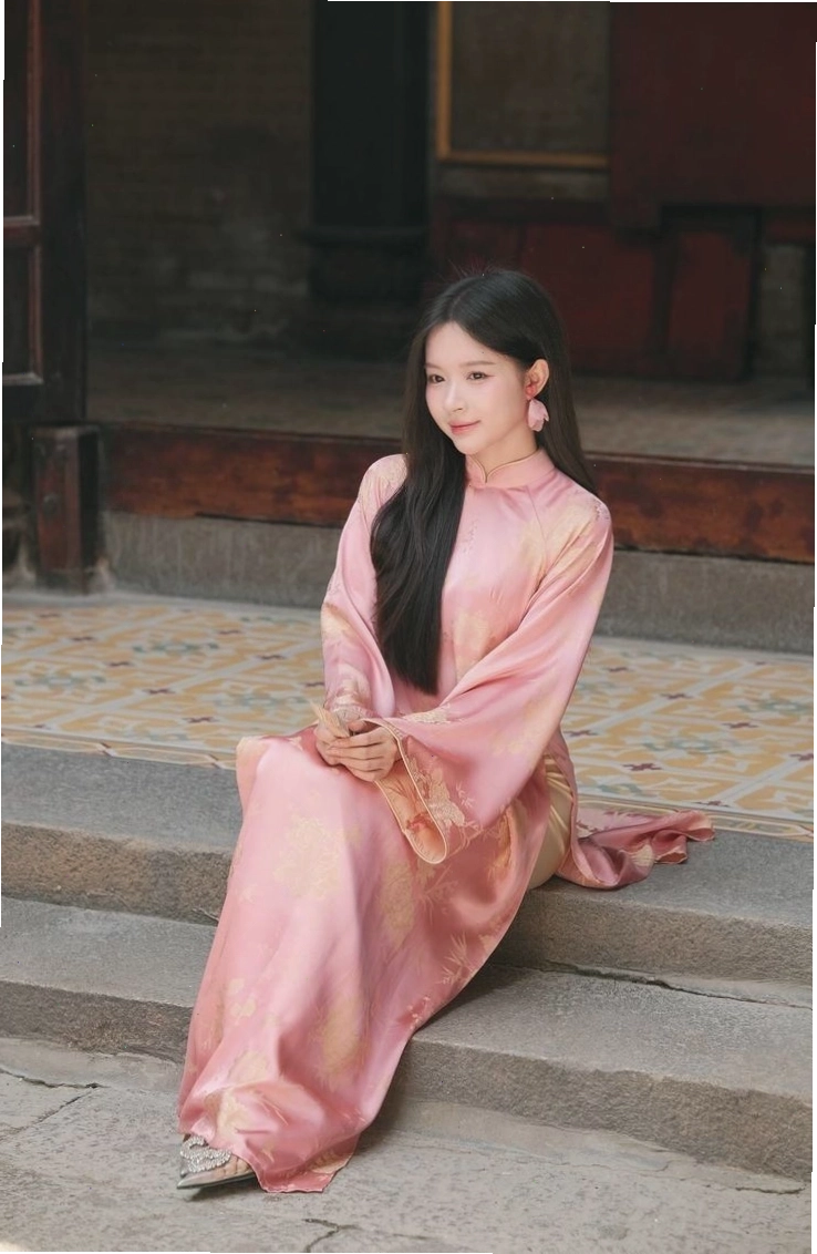 Áo dài màu vàng chanh pastel, tay phồng, phối cùng quần culottes trắng và túi cói