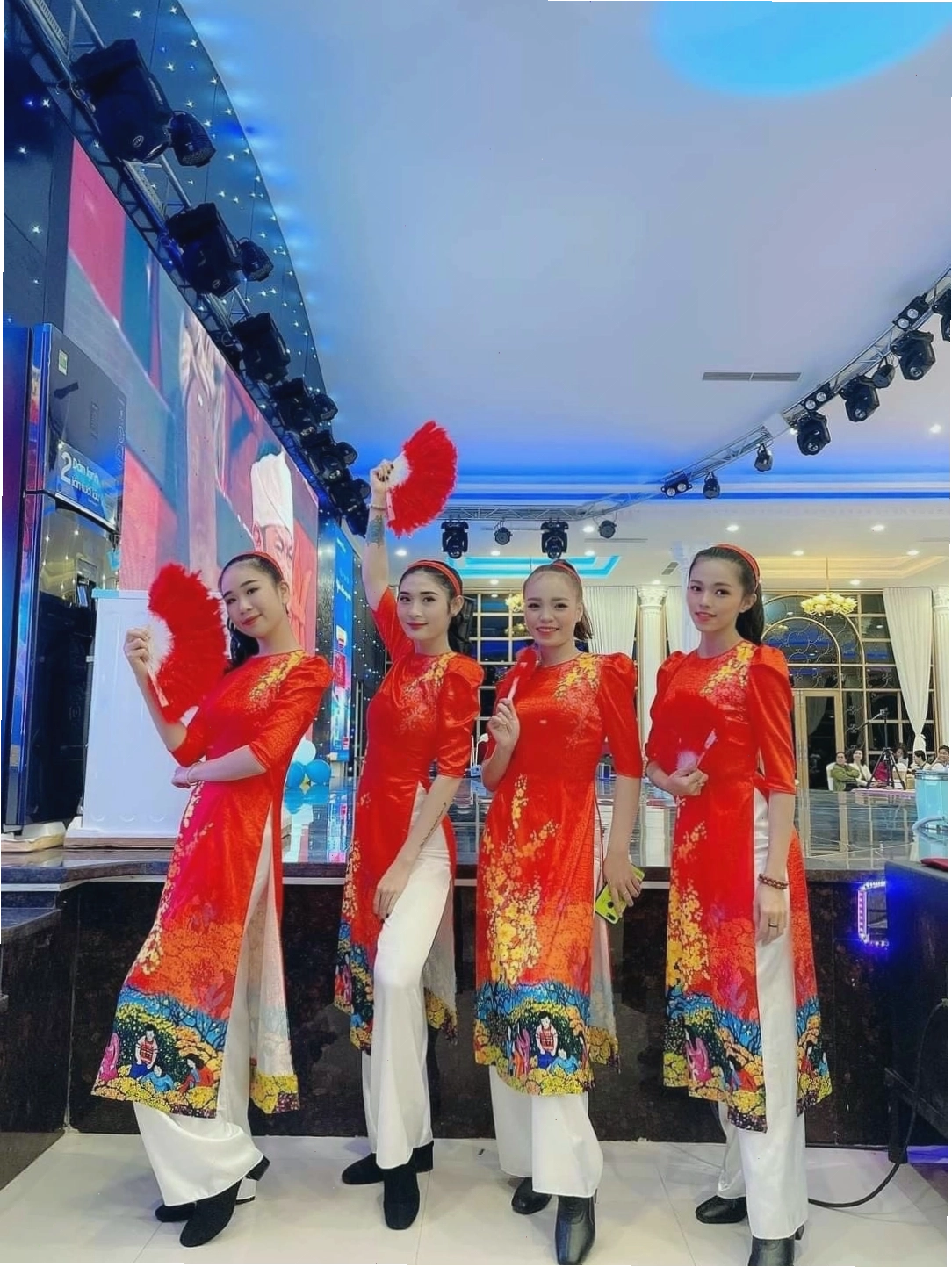 Áo dài múa đỏ rực rỡ, cổ tròn, tay lỡ, họa tiết hoa văn thêu chỉ vàng