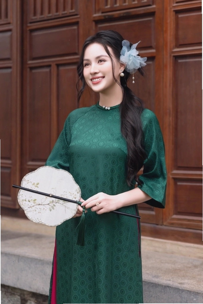 Áo dài nhung xanh lá đính ngọc trai dọc theo đường cúc áo