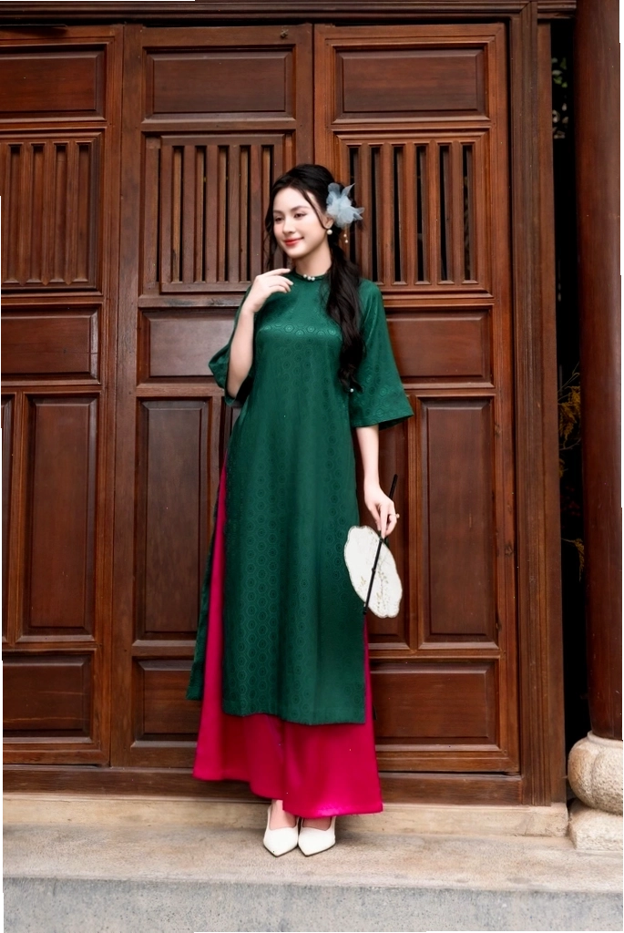 Áo dài nhung xanh lá đính ngọc trai ở cổ tròn và tay áo