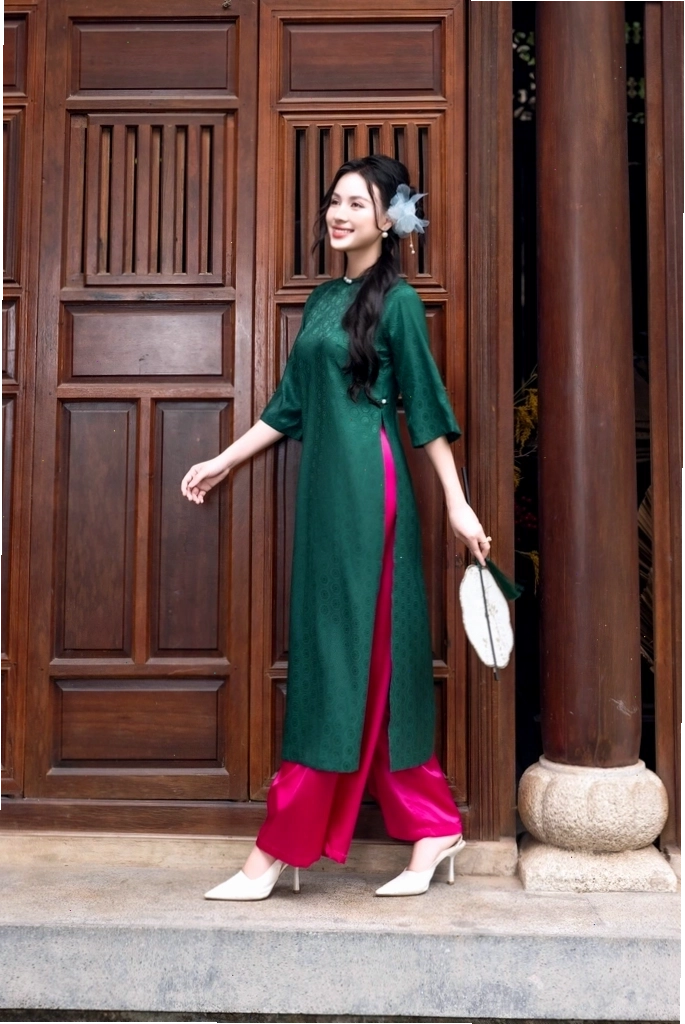 Áo dài nhung xanh lá đính ngọc trai quanh cổ tay và tà áo