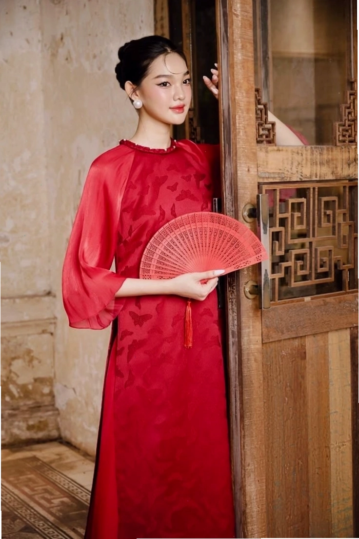 Áo dài tà ngắn, cổ tròn, tay lỡ, họa tiết cánh bướm, phối cùng quần lụa trắng