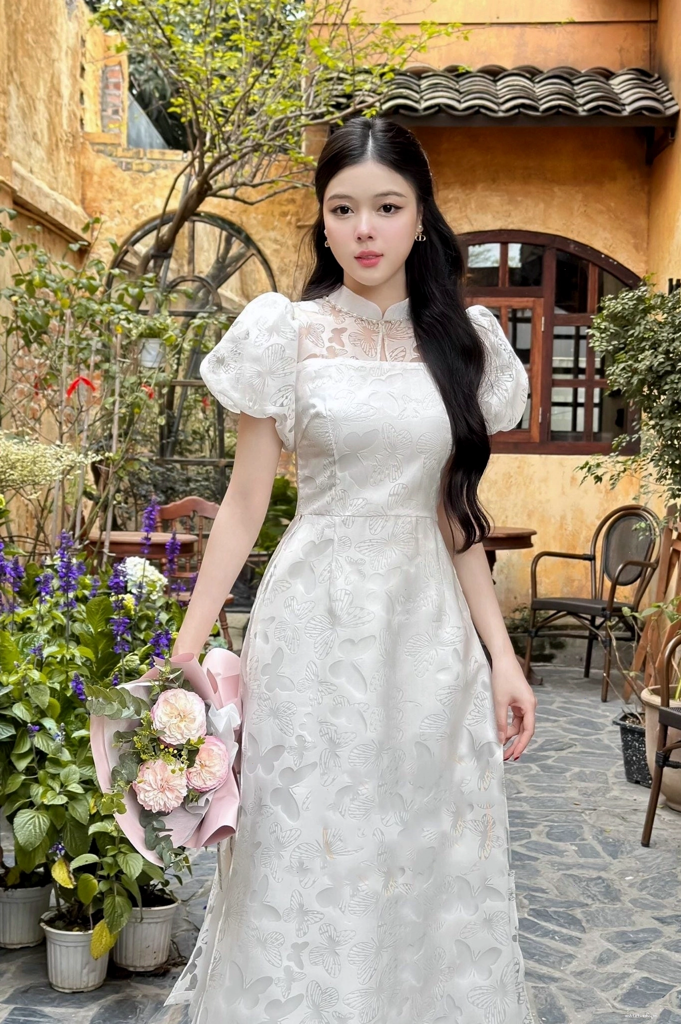 Áo dài tay phồng cổ màu trắng tinh khôi họa tiết dập nổi, phối cùng quần lụa trắng