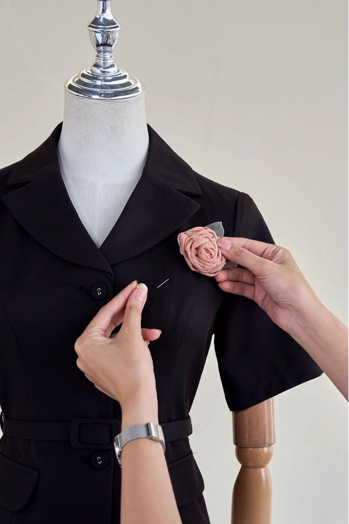 Áo khoác dáng lửng màu đen trơn, cổ vest, có đai eo thắt nơ, phù hợp phối cùng đầm dạ hội