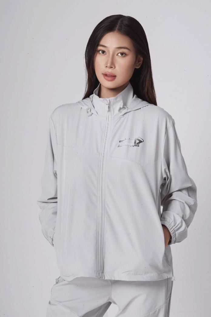 Áo khoác nữ dáng dài màu xám có mũ, phối cùng quần legging và giày thể thao
