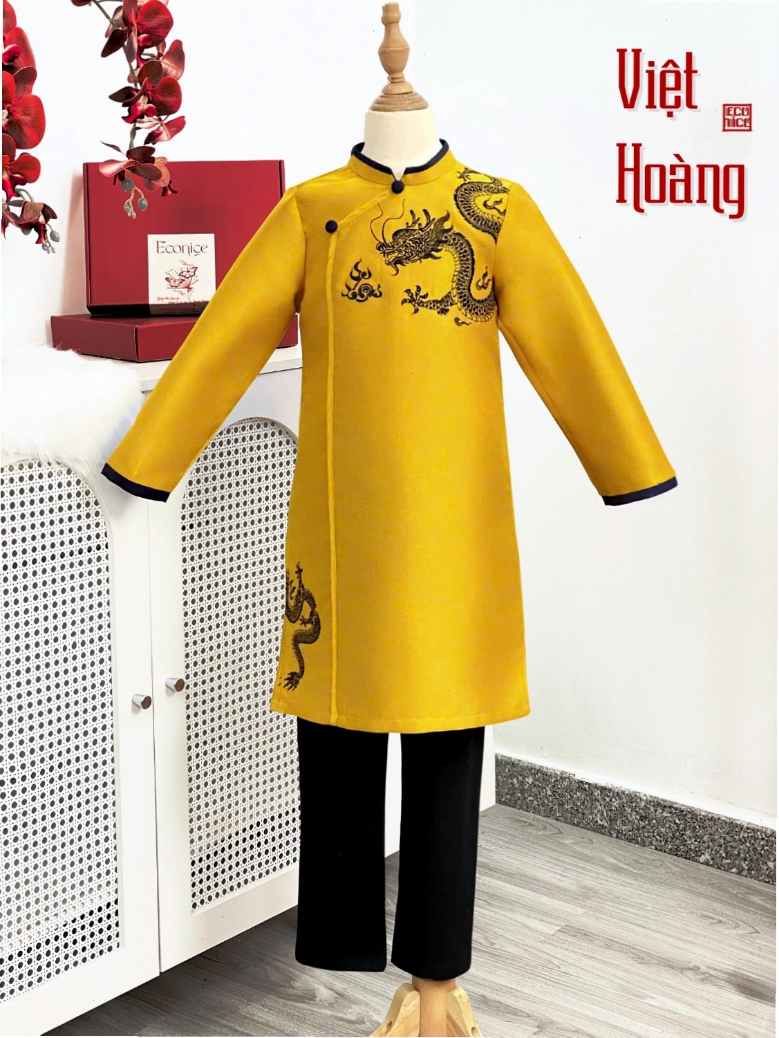 Bé trai diện áo dài cách tân màu đỏ tươi, họa tiết hoa văn nổi, phối quần đen