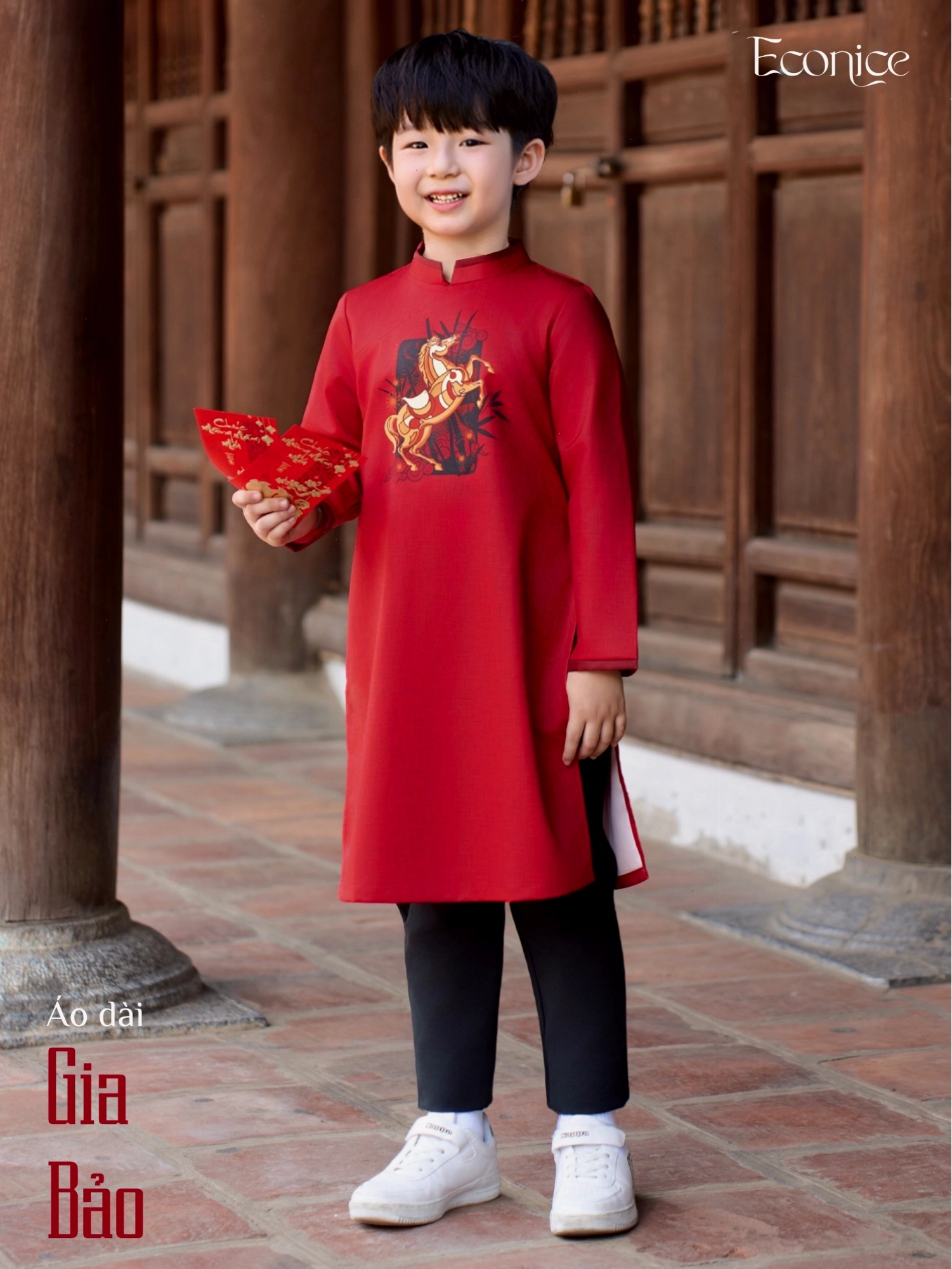 Bé trai diện áo dài cách tân màu xanh dương với họa tiết rồng tinh xảo, phối cùng quần trắng năng động