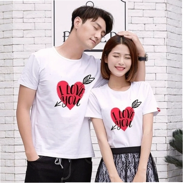 Cặp đôi diện áo hoodie màu be và quần jogger, tạo dáng ngồi trên bậc thang, nhìn về phía xa