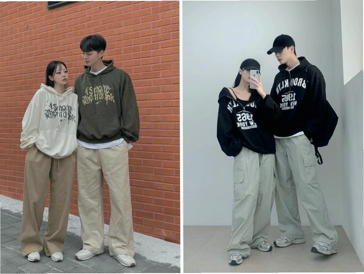 Cặp đôi diện áo hoodie oversize màu xám và đen, quần jeans rách tạo dáng tự tin trên phố đông đúc