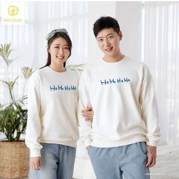 Cặp đôi diện áo hoodie vải nỉ da cá, tạo dáng ngồi cạnh nhau trên ghế đá