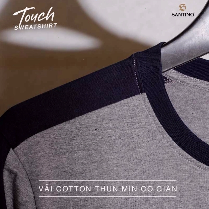 Cặp đôi diện áo khoác phao đôi màu xanh navy, quần jeans, tạo dáng vui đùa trên bãi biển mùa đông