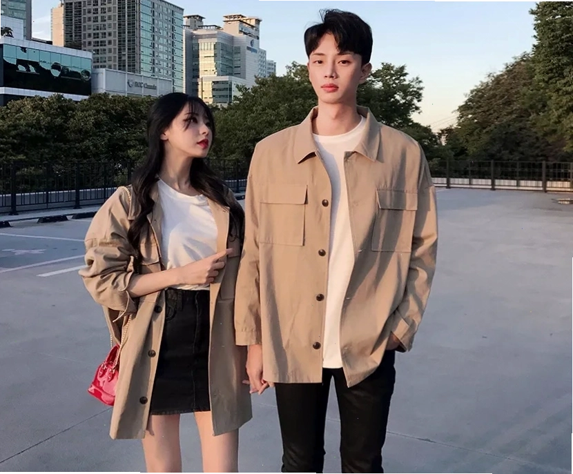 Cặp đôi diện áo sơ mi kẻ sọc và quần short, tạo dáng nhìn nhau cười tươi dưới ánh nắng
