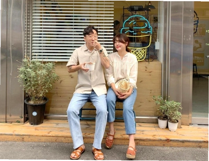 Cặp đôi diện áo sơ mi và quần jeans, ngồi cạnh nhau trong một quán cà phê