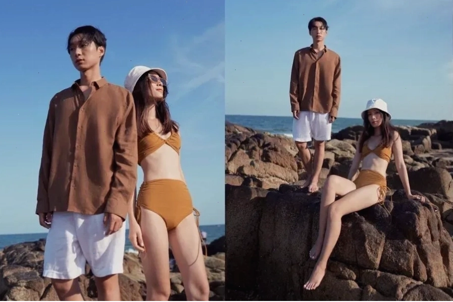 Cặp đôi diện đồ bơi đôi đi biển, cô gái đang tạo dáng nhí nhảnh bên chàng trai