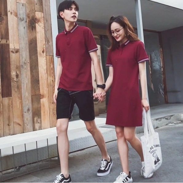 Cặp đôi diện set đồ đôi cổ bẻ màu xanh và trắng, tạo dáng tình tứ trên bãi biển