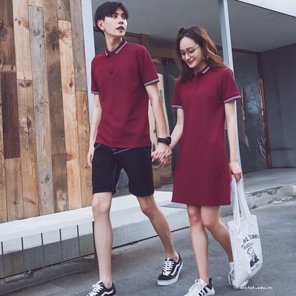 Cặp đôi diện set đồ đôi gồm áo sơ mi trắng và chân váy chữ A họa tiết kẻ caro, tạo dáng tự tin