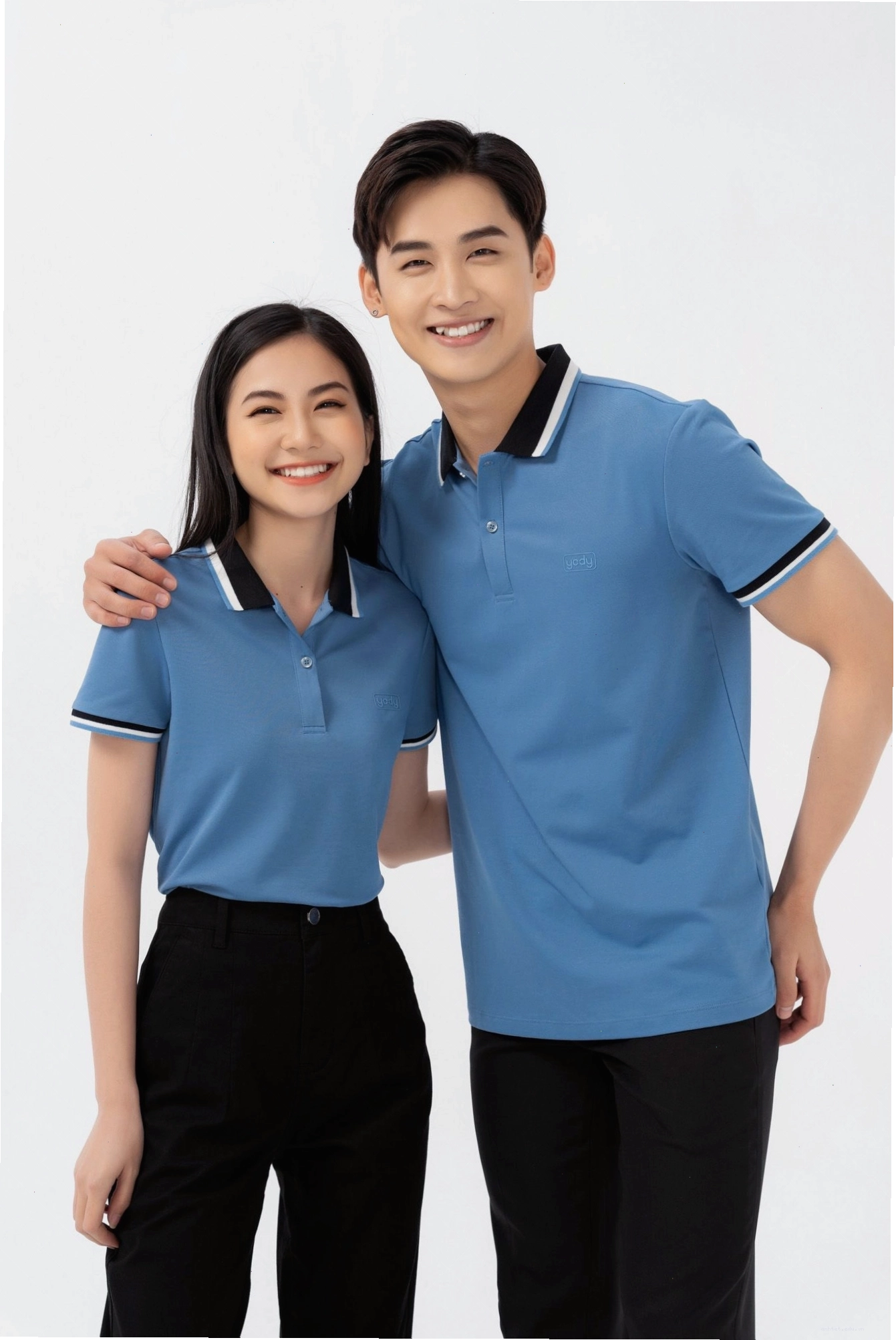 Cặp đôi mặc áo đôi cổ tròn màu be, tạo dáng nắm tay nhau đi dạo