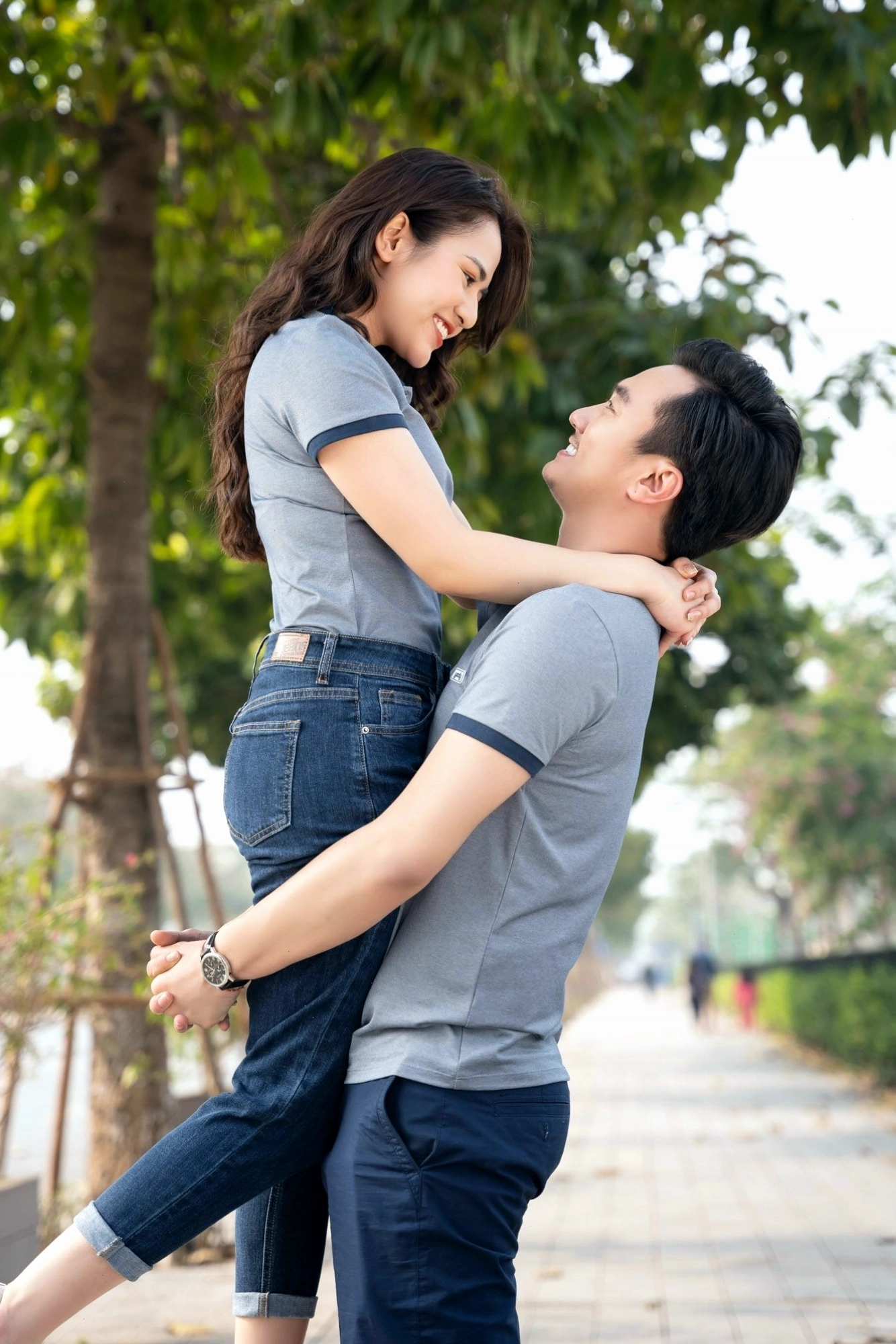 Cặp đôi mặc áo đôi màu vàng và trắng, tạo dáng tựa đầu vào nhau