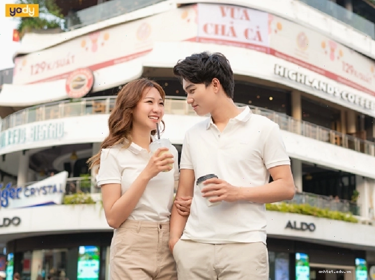 Cặp đôi mặc áo đôi màu xanh dương và trắng, tạo dáng đứng quay lưng lại với nhau