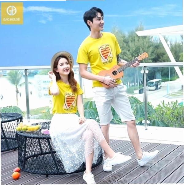 Cặp đôi mặc áo đôi màu xanh dương và trắng, tạo dáng tình tứ trên bãi biển