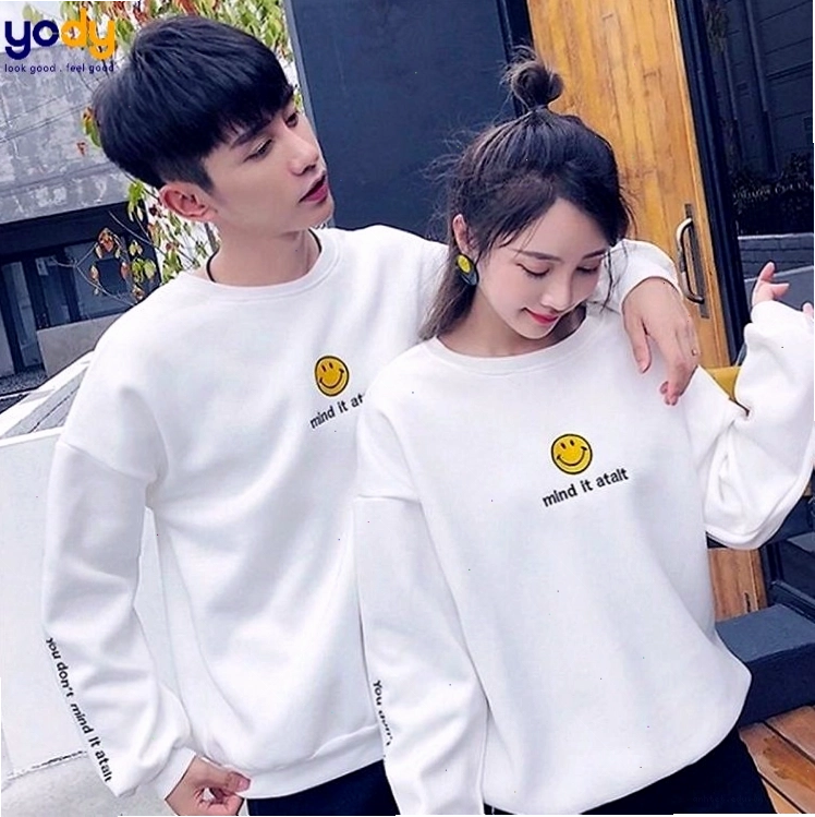 Cặp đôi mặc áo hoodie đôi màu hồng và xám, quần jeans, tạo dáng cười tươi