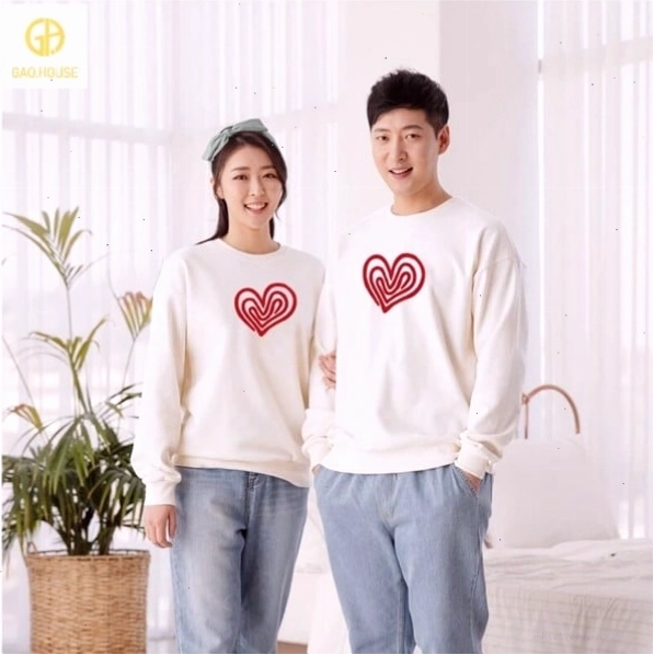 Cặp đôi mặc áo hoodie đôi màu xám, tạo dáng ngồi trên bậc thang