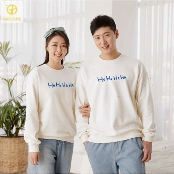 Cặp đôi mặc áo hoodie đôi màu xám, vui vẻ dựa vào nhau trong không khí se lạnh