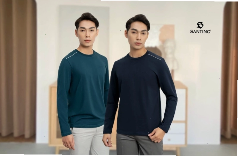 Cặp đôi mặc áo hoodie màu be và nâu, quần jean đen, tạo dáng nắm tay nhau trên phố