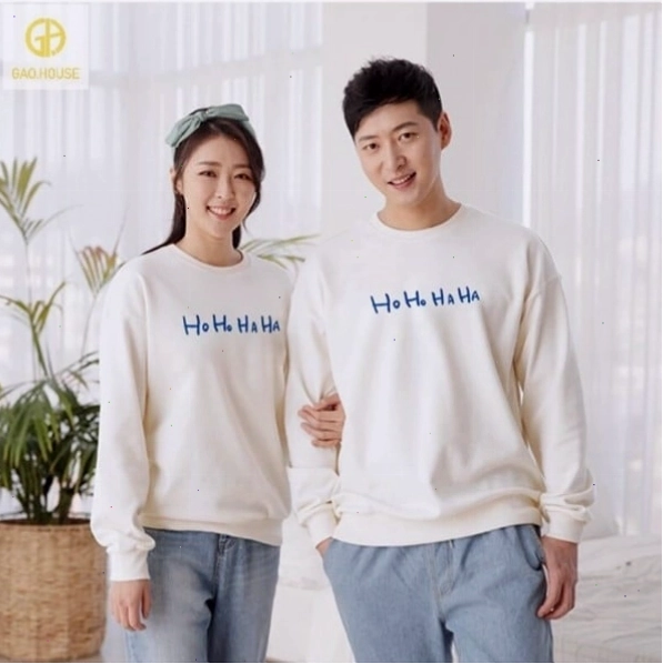 Cặp đôi mặc áo hoodie màu xám và quần đen, ngồi trên ghế dài công viên, nhìn nhau trìu mến