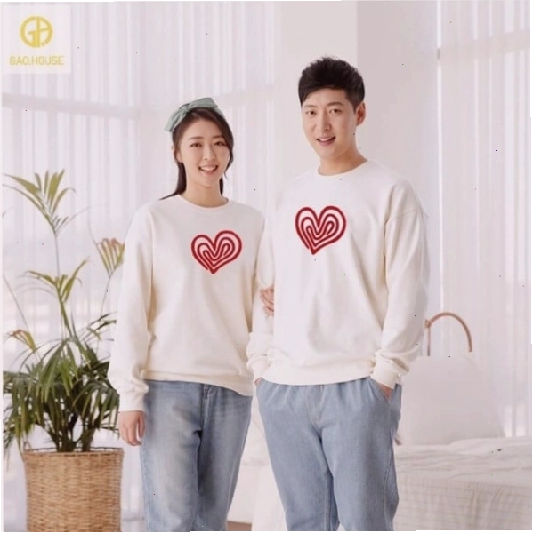 Cặp đôi mặc áo hoodie vải nỉ da cá, tạo dáng ngồi cạnh nhau đọc sách