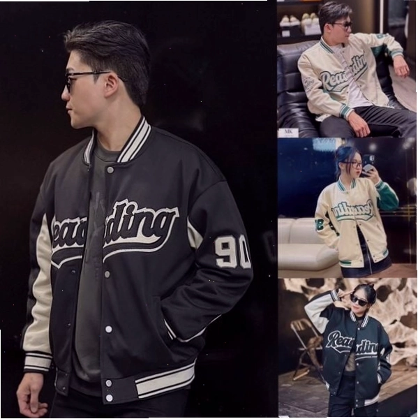 Cặp đôi mặc áo khoác bomber đen giống nhau, nắm tay nhau dạo bước trên phố đông người