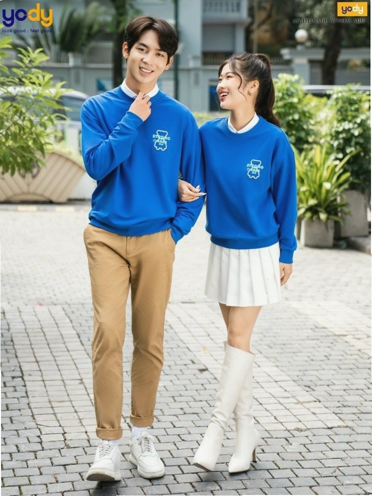 Cặp đôi mặc áo len cổ lọ đôi màu trắng và đen, quần jean, tạo dáng tựa đầu vào nhau