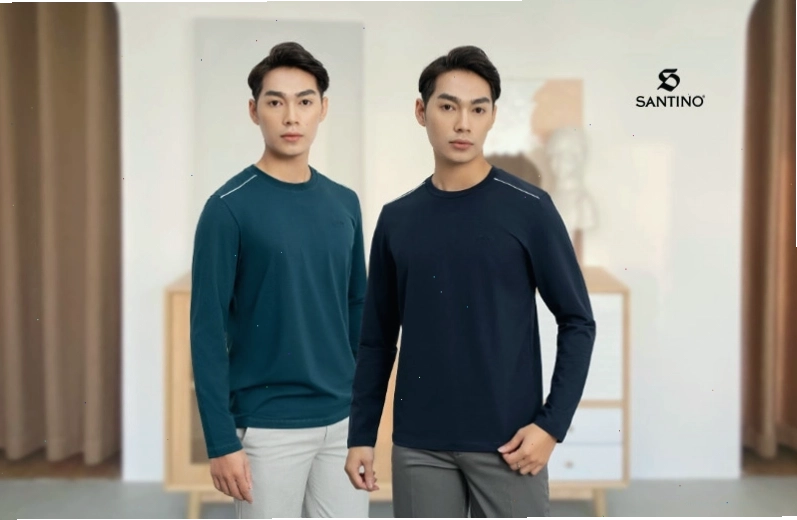 Cặp đôi mặc áo len cổ lọ màu be và nâu, quần kaki, tạo dáng tựa đầu vào nhau