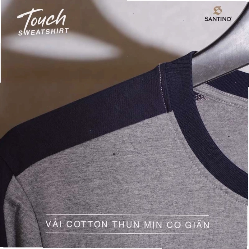 Cặp đôi mặc áo sơ mi kẻ và quần tây, tạo dáng nhìn ra cửa sổ quán cà phê
