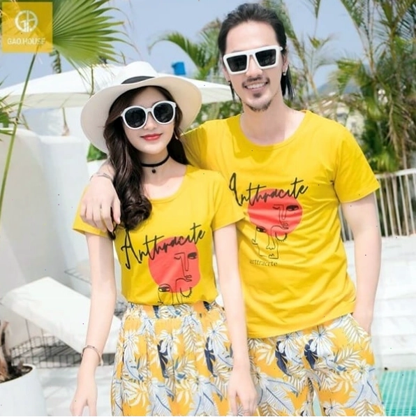 Cặp đôi mặc áo thun đôi gam màu xanh navy, nắm tay nhau dạo biển